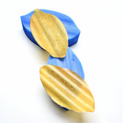 Blue silicone wavy calisson molds with textured golden pastry tuiles.