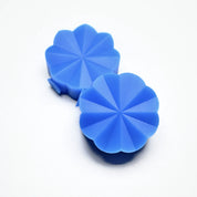 Two blue silicone Helios pastry presses with a radiant, flower-like starburst design.