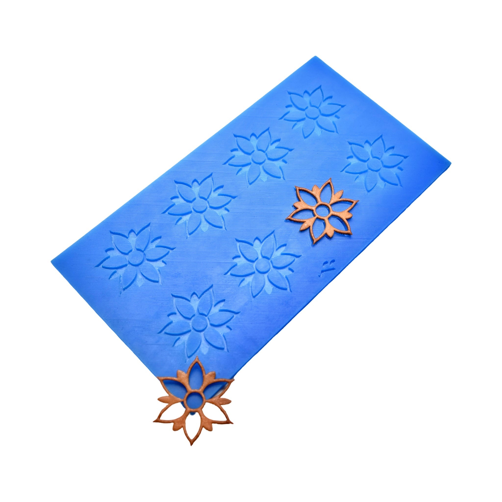 Blue silicone Onalia tuile mat with flower-shaped molds and gold decorative tuiles.