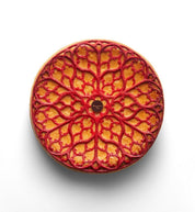 Intricate red gothic rosette tuile on a round pastry, made with the Regalia silicone mat.