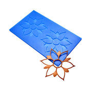 Blue silicone Onalia tuile mat with two flower-shaped molds and a finished bronze tuile.