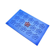 Blue silicone tuile mat with cherry blossom molds and one orange sakura tuile.