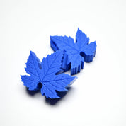 Blue silicone vine leaf molds with detailed vein textures on a white background.