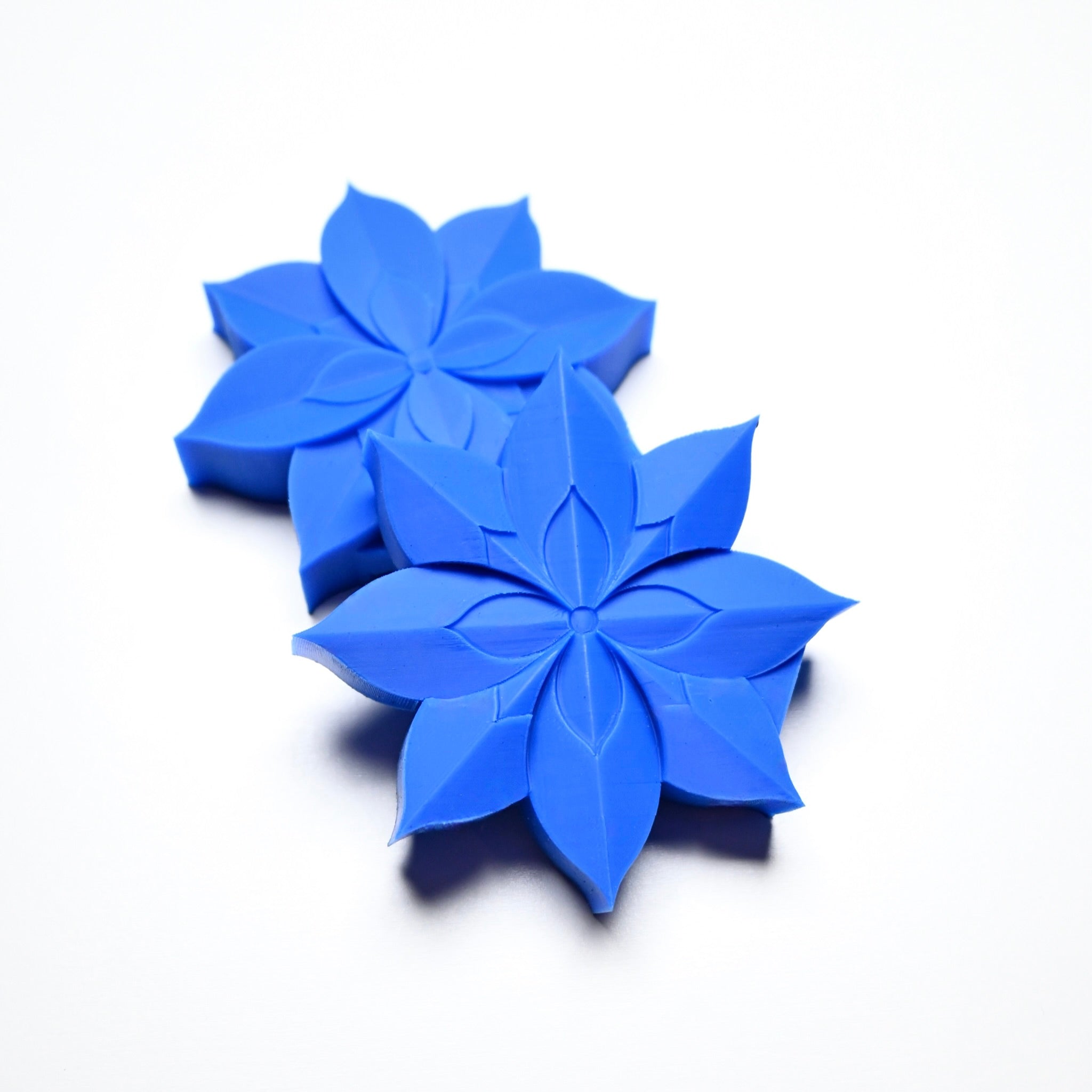 Two blue silicone lotus flower pastry presses with detailed petal shapes on a white background.