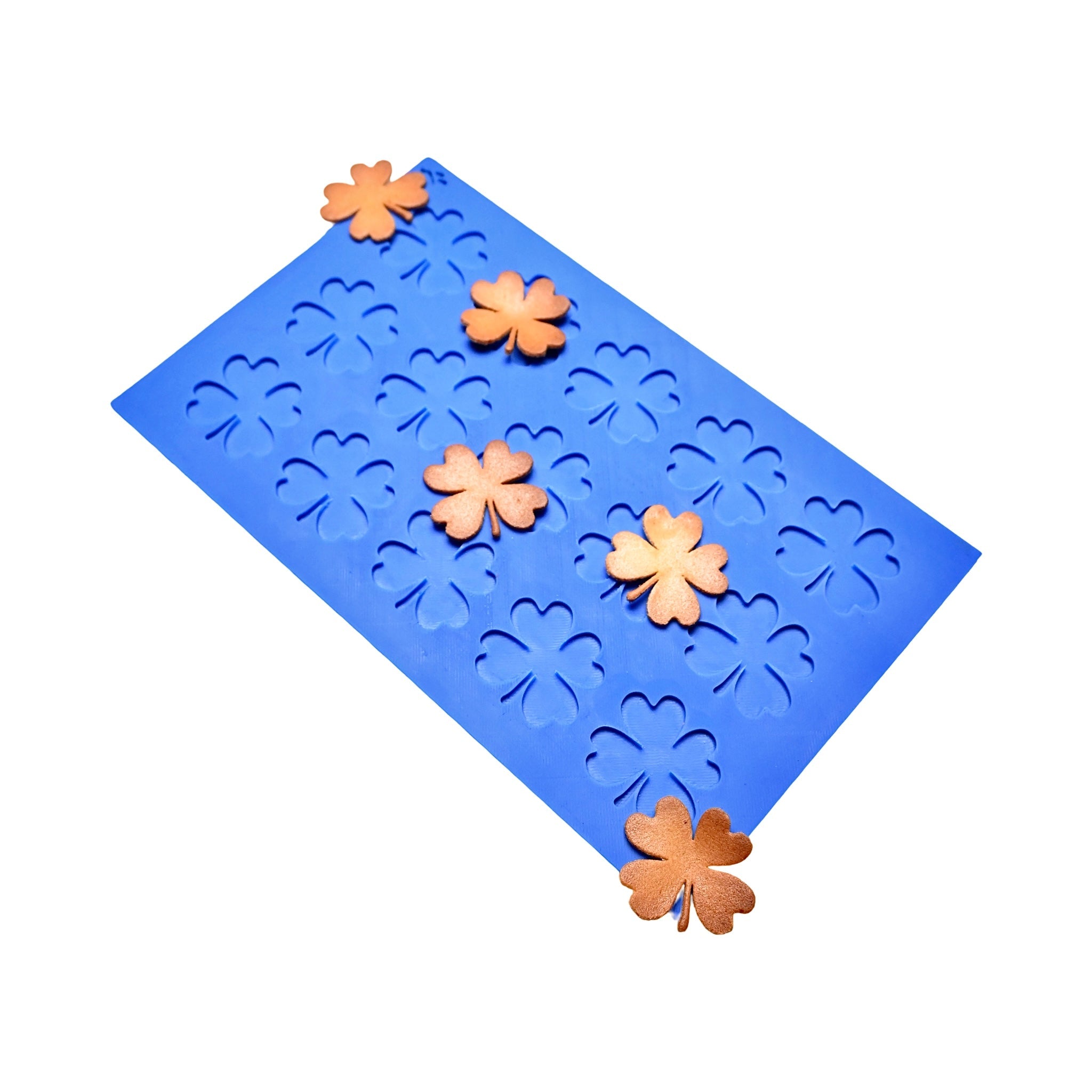Blue silicone Oxalis tuile mat with clover-shaped molds and golden baked tuiles.