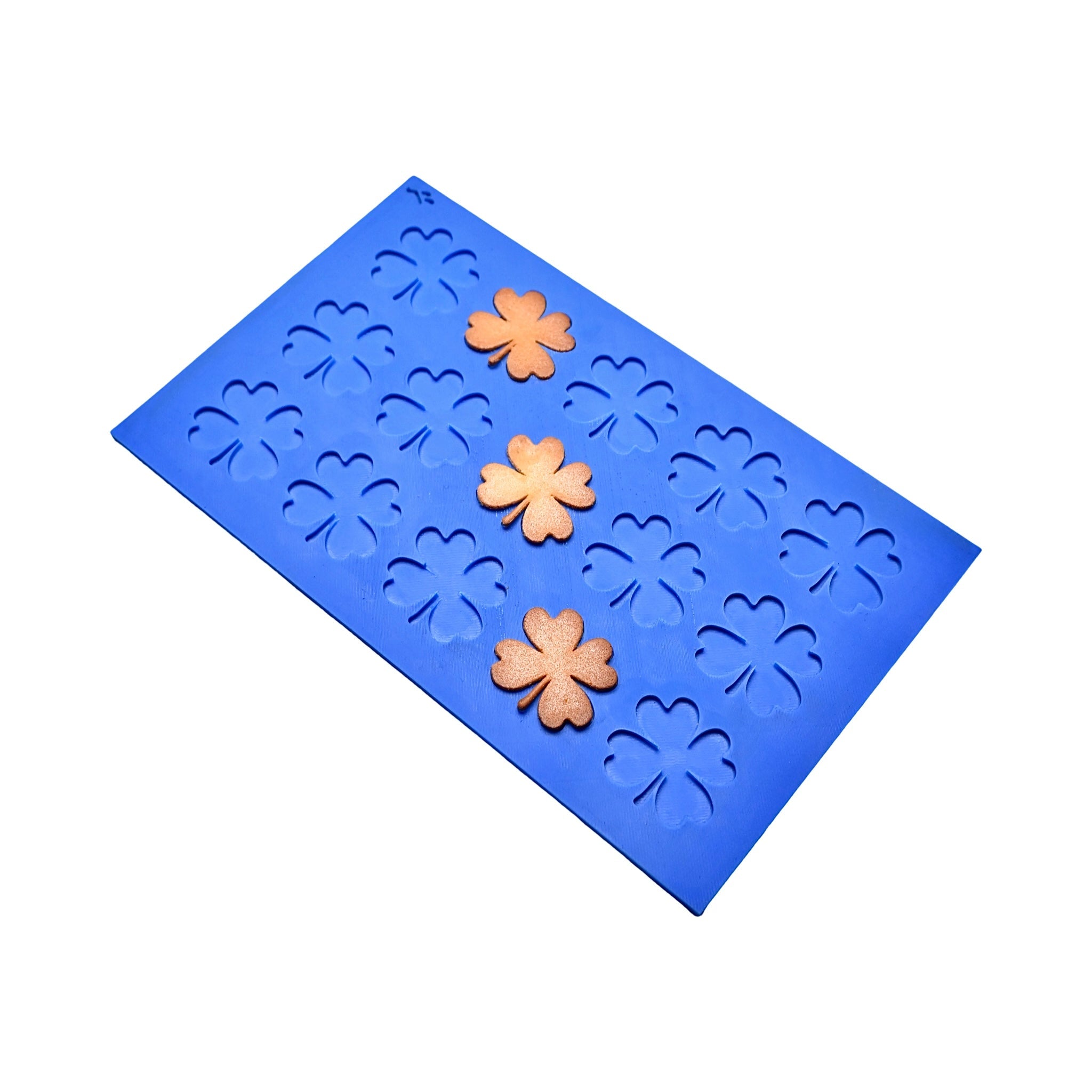 Blue silicone Oxalis tuile mat with clover-shaped molds and golden leaf tuiles.