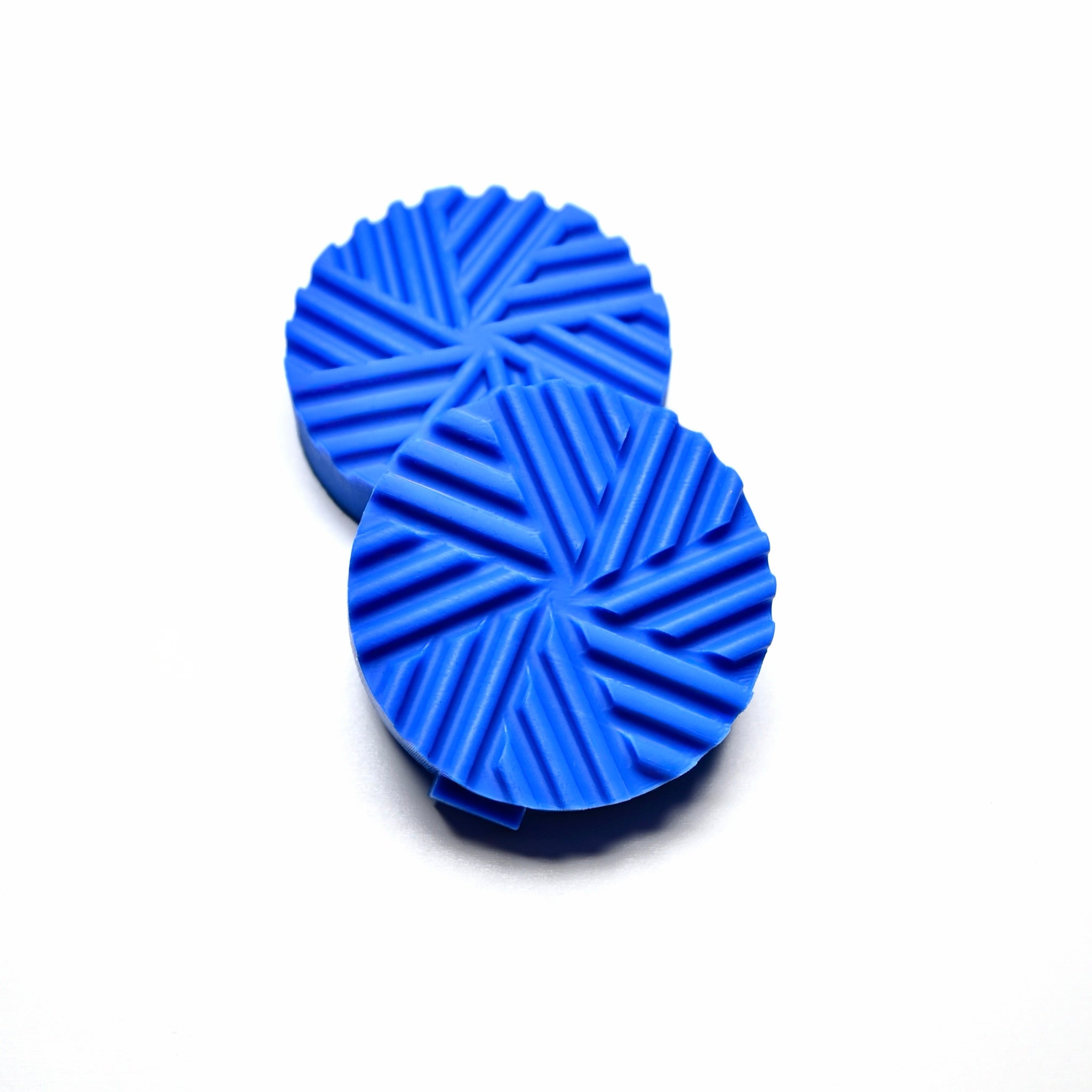 Two blue round silicone Helix pastry presses with a spiral geometric design.