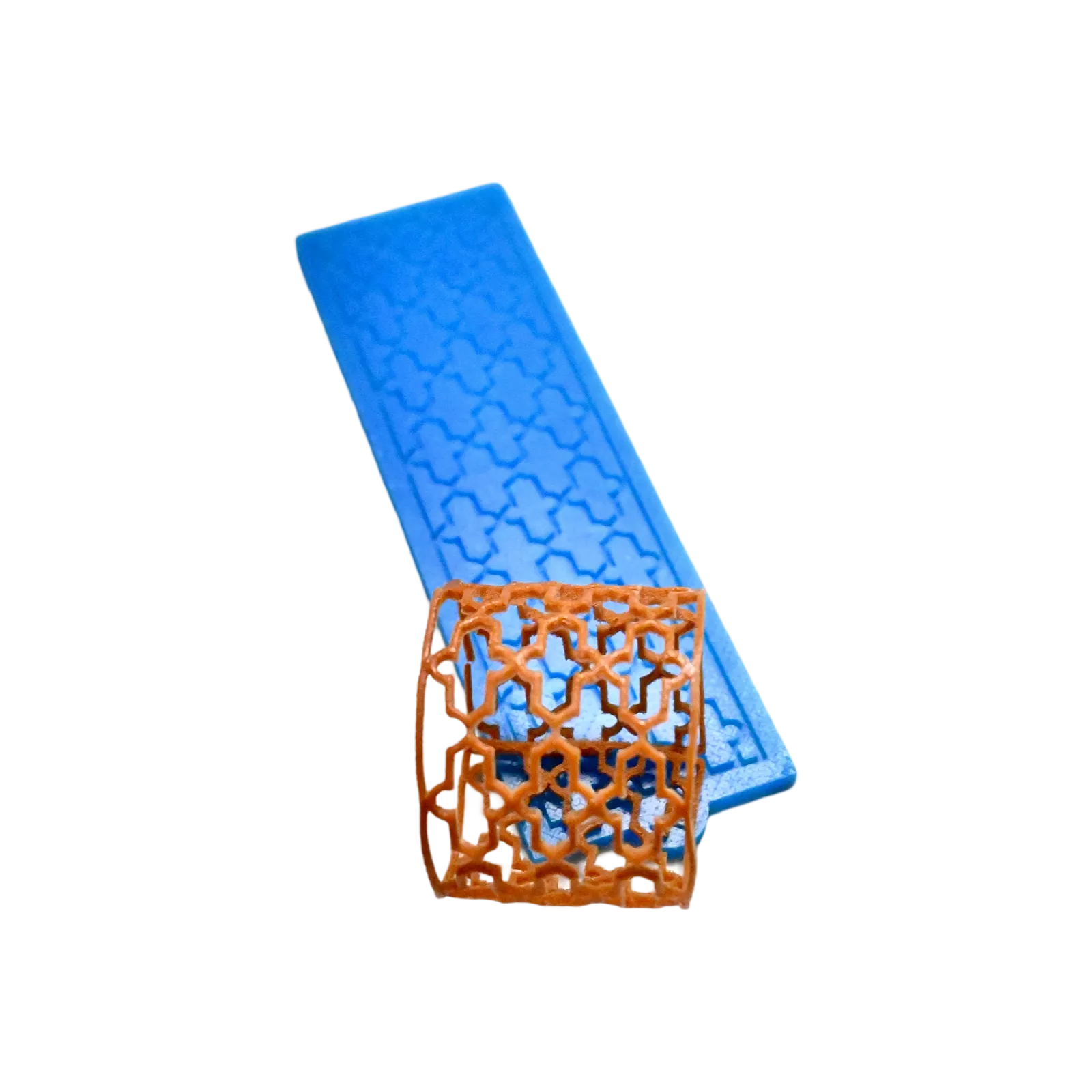 Blue silicone Baroque tuile mat with a curved, brown lace pastry garnish.