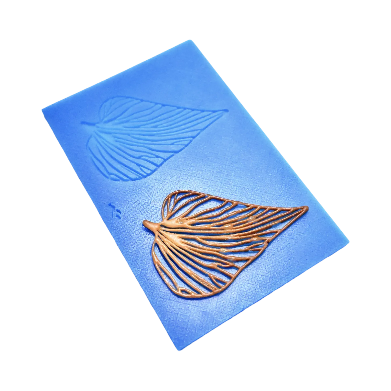 Blue silicone Folia tuile mat with leaf-shaped molds and a golden edible leaf garnish.