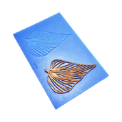 Blue silicone Folia tuile mat with leaf-shaped molds and a golden edible leaf garnish.