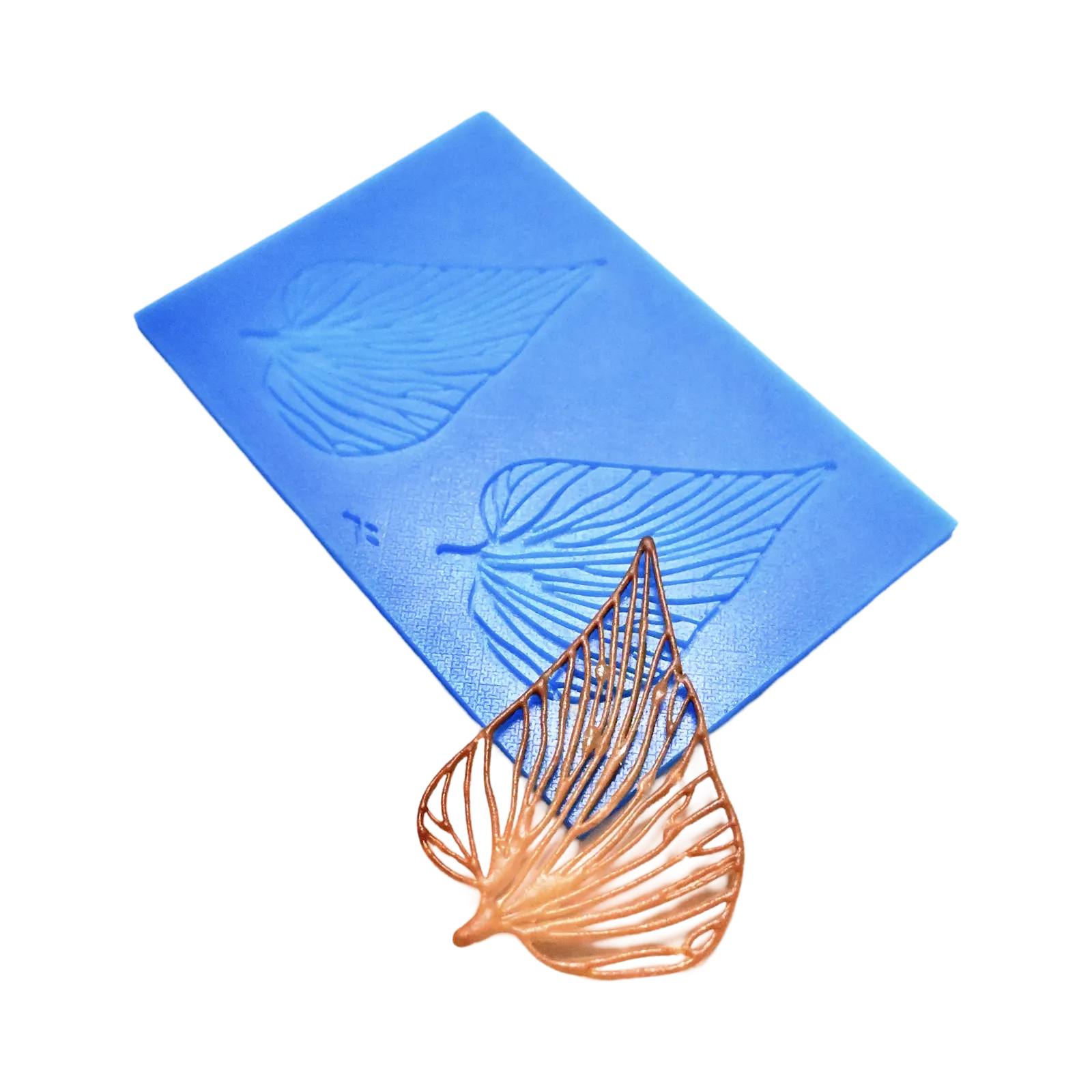 Blue silicone Folia tuile mat with leaf-shaped molds and a delicate golden-brown leaf garnish.