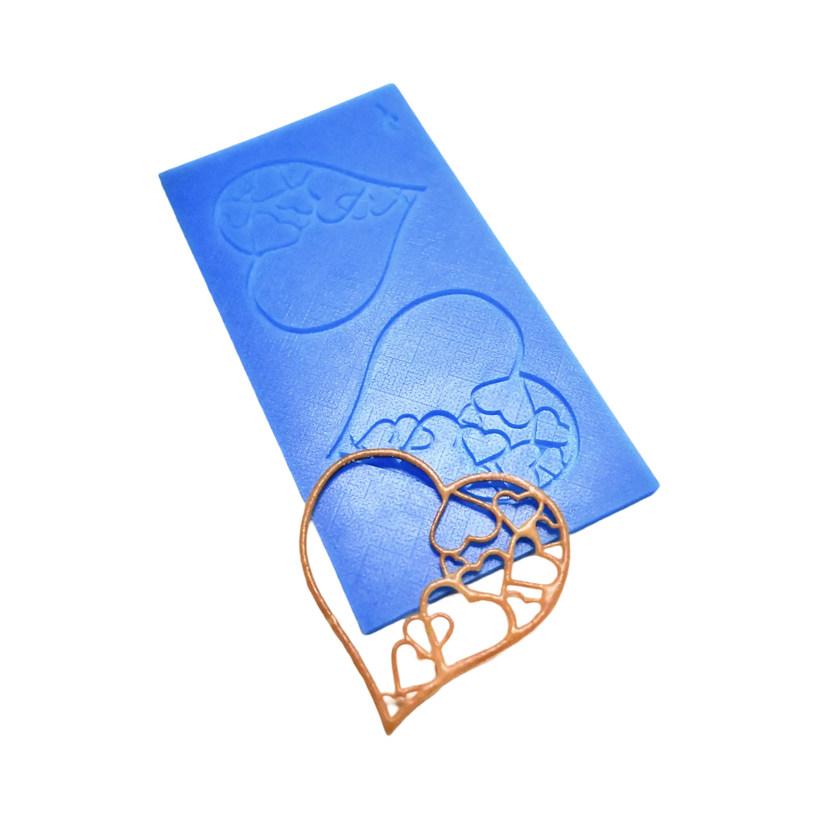 Blue silicone tuile mat with intricate heart-shaped molds and a golden edible heart decoration.