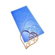 Blue silicone tuile mat with intricate heart-shaped molds and a golden edible heart decoration.