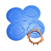 Blue silicone Spirulina tuile mat with four sunburst-shaped molds and a golden-brown baked garnish.