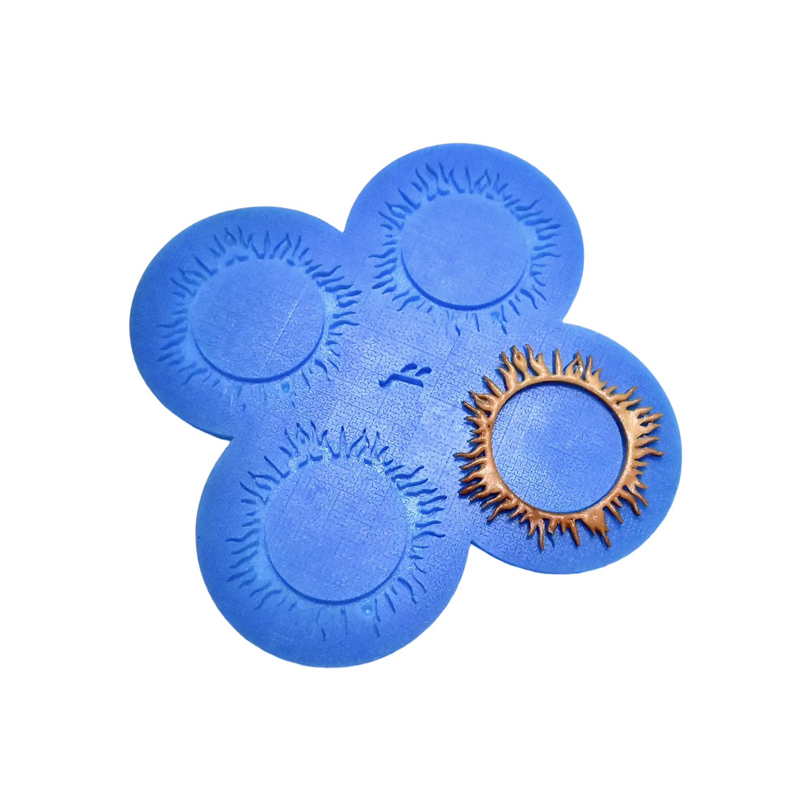 Blue silicone spirulina tuile mat with circular, sunburst-shaped molds and a golden garnish.