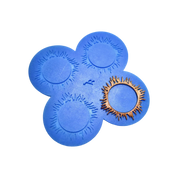 Blue silicone spirulina tuile mat with circular, sunburst-shaped molds and a golden garnish.