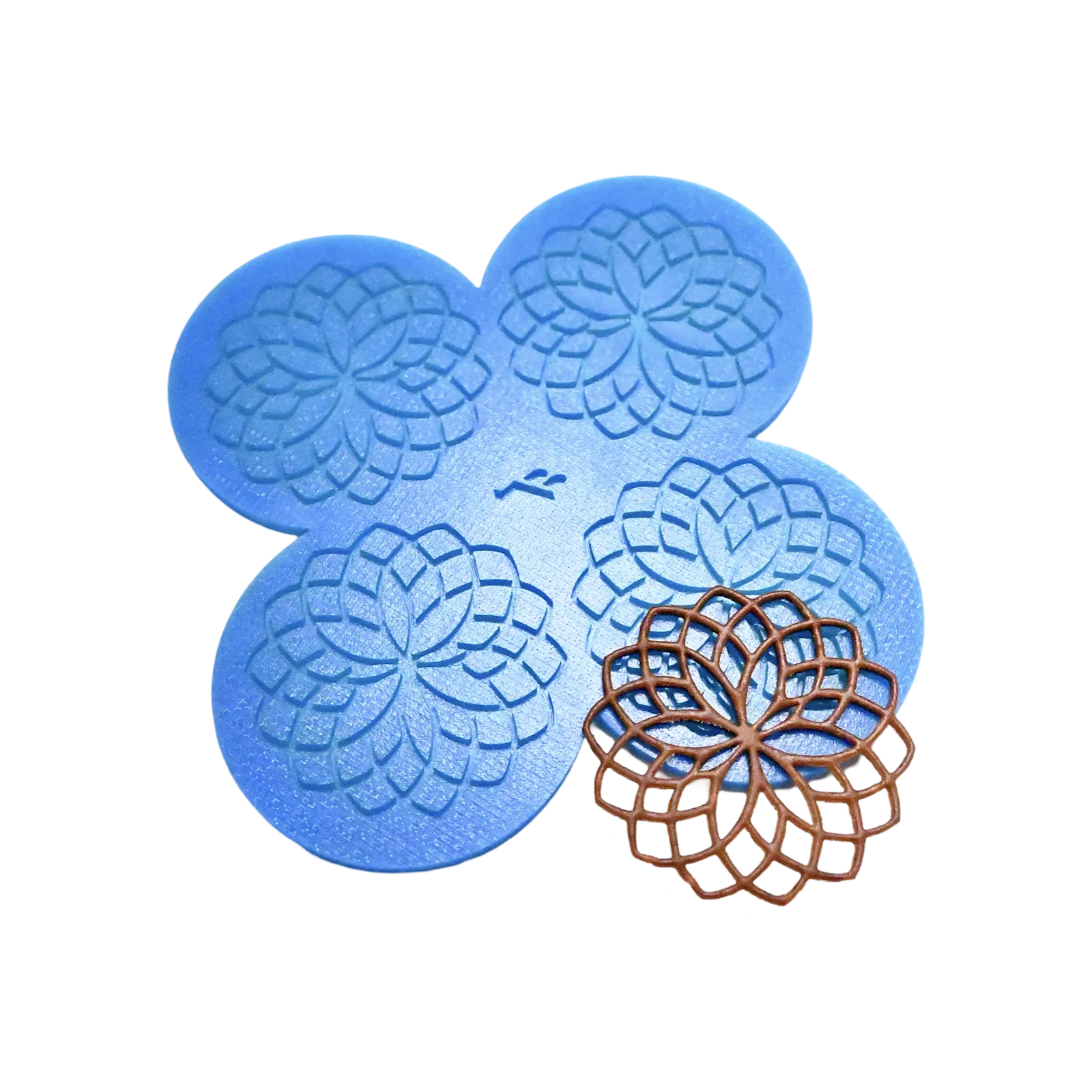 Blue silicone rosette tuile mat with four circular geometric flower molds and a brown baked tuile.