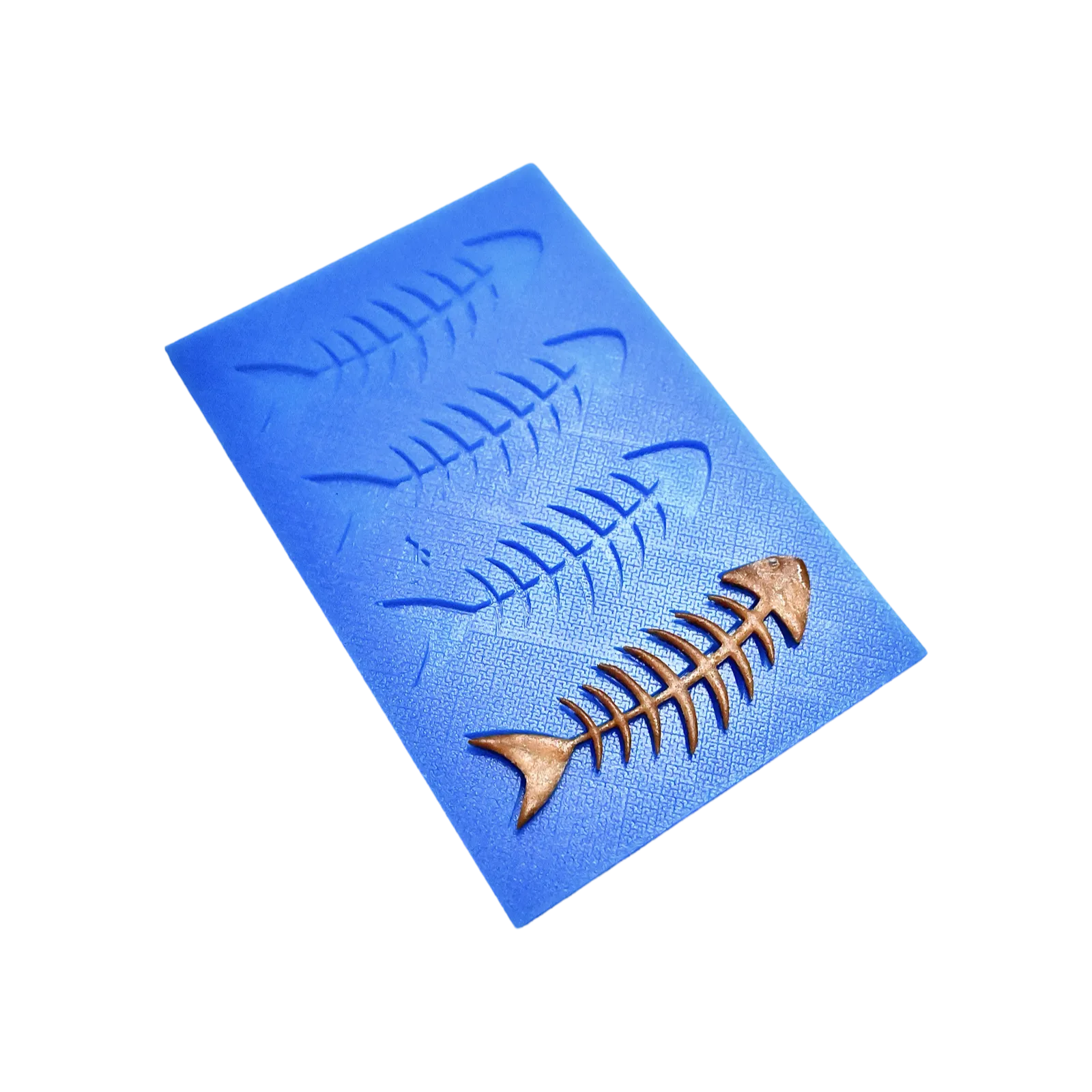Blue silicone tuile mat with fish skeleton shaped molds and a bronze-colored tuile.