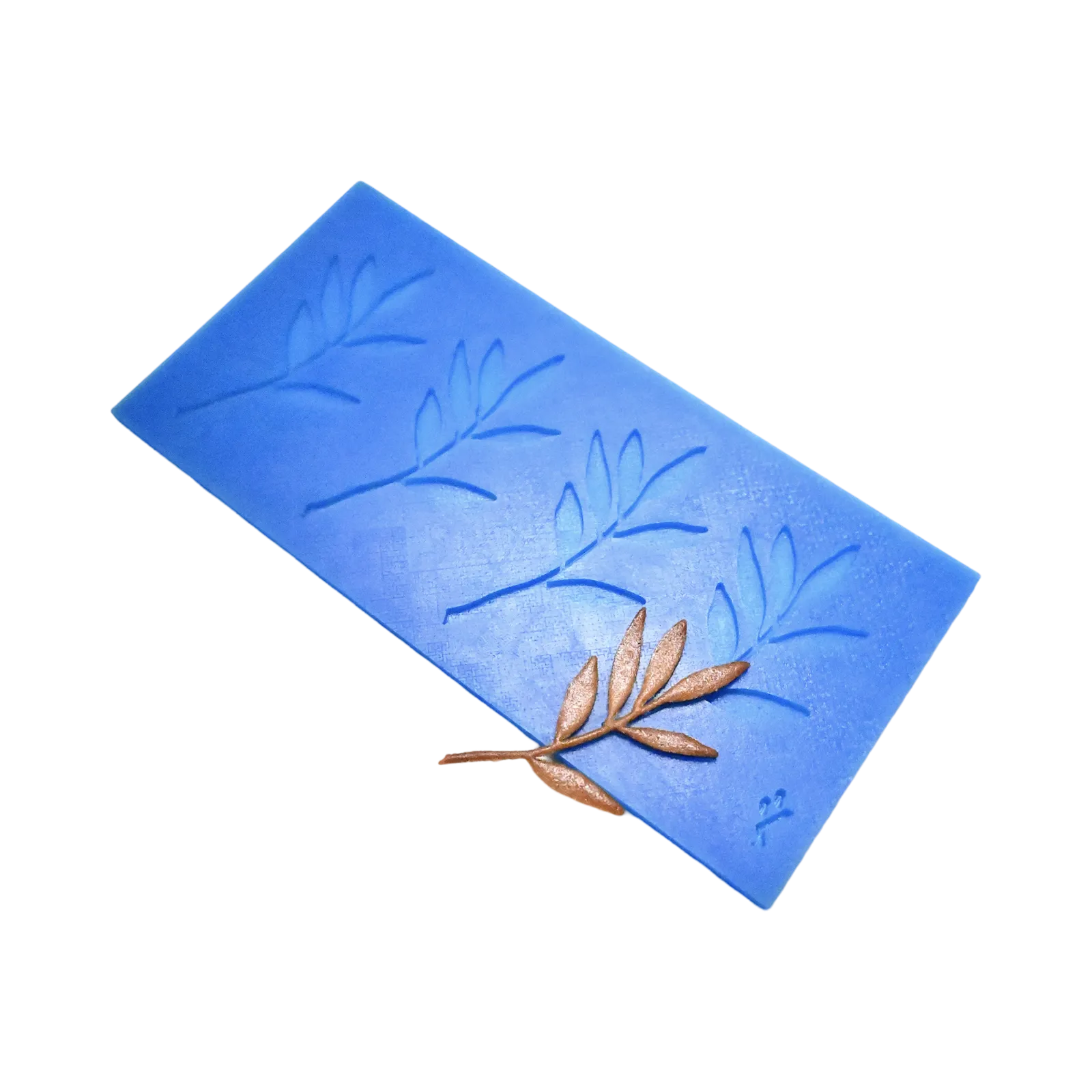 Blue silicone tuile mat with four olive branch shaped molds and a bronze garnish.