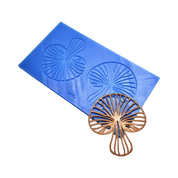 Blue silicone mat with mushroom-shaped tuile molds next to a brown, detailed mushroom garnish.