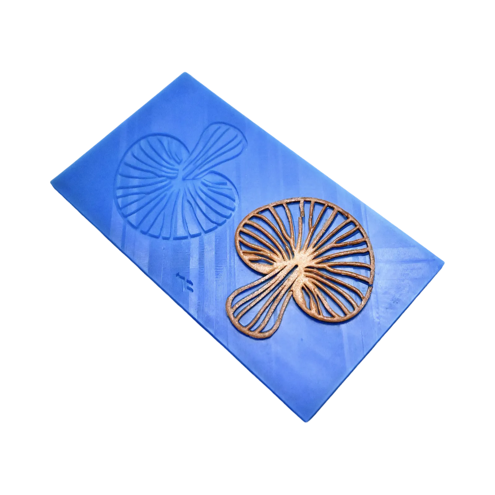 Blue silicone tuile mat with detailed mushroom-shaped molds and a golden-brown baked tuile.