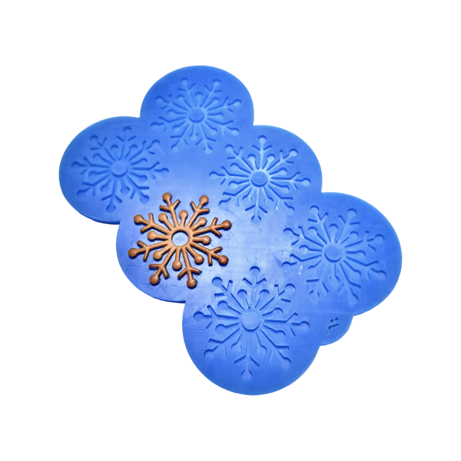 Blue silicone snowflake tuile mold with a finished brown snowflake pastry.
