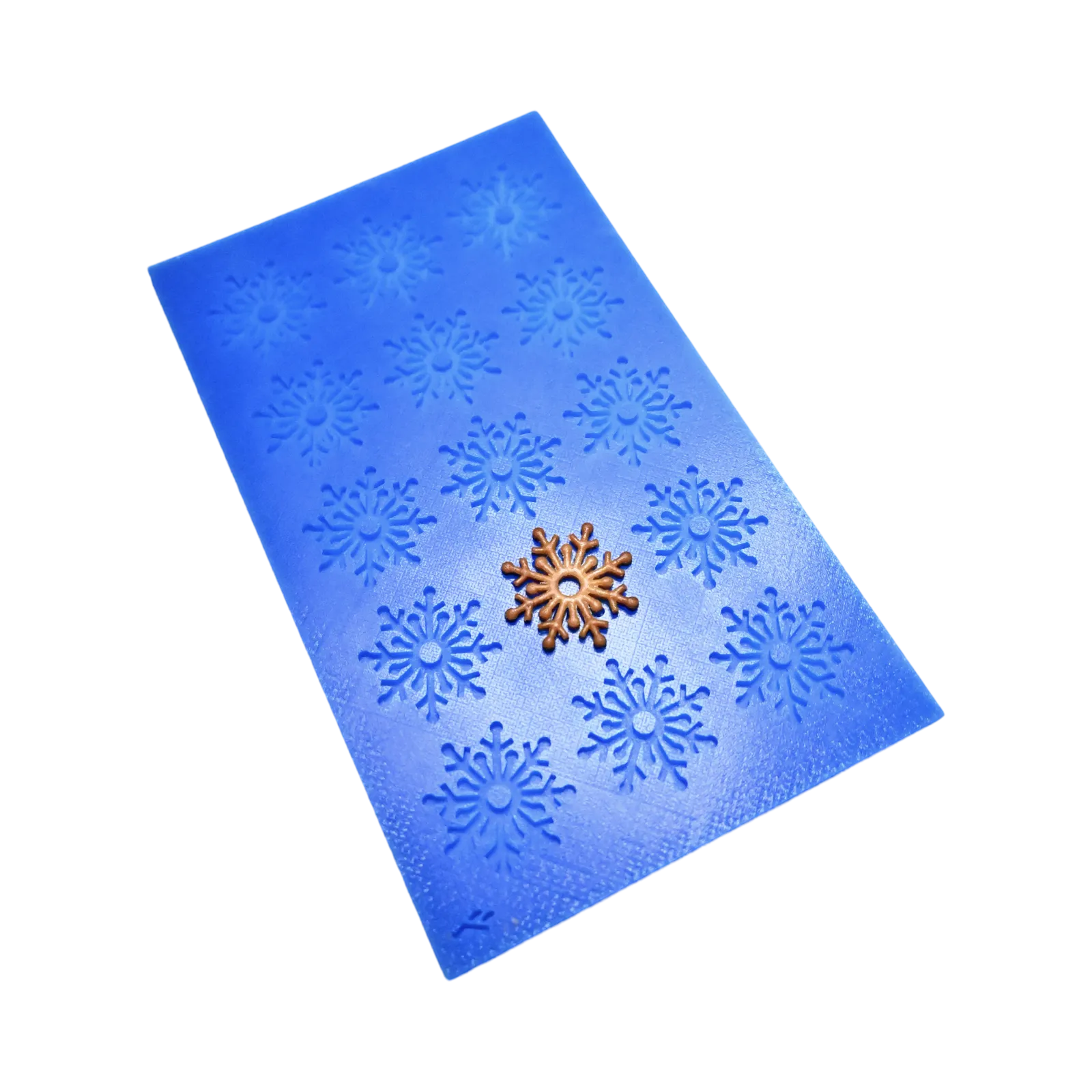Blue silicone snowflake tuile mold with a golden snowflake pastry on top.