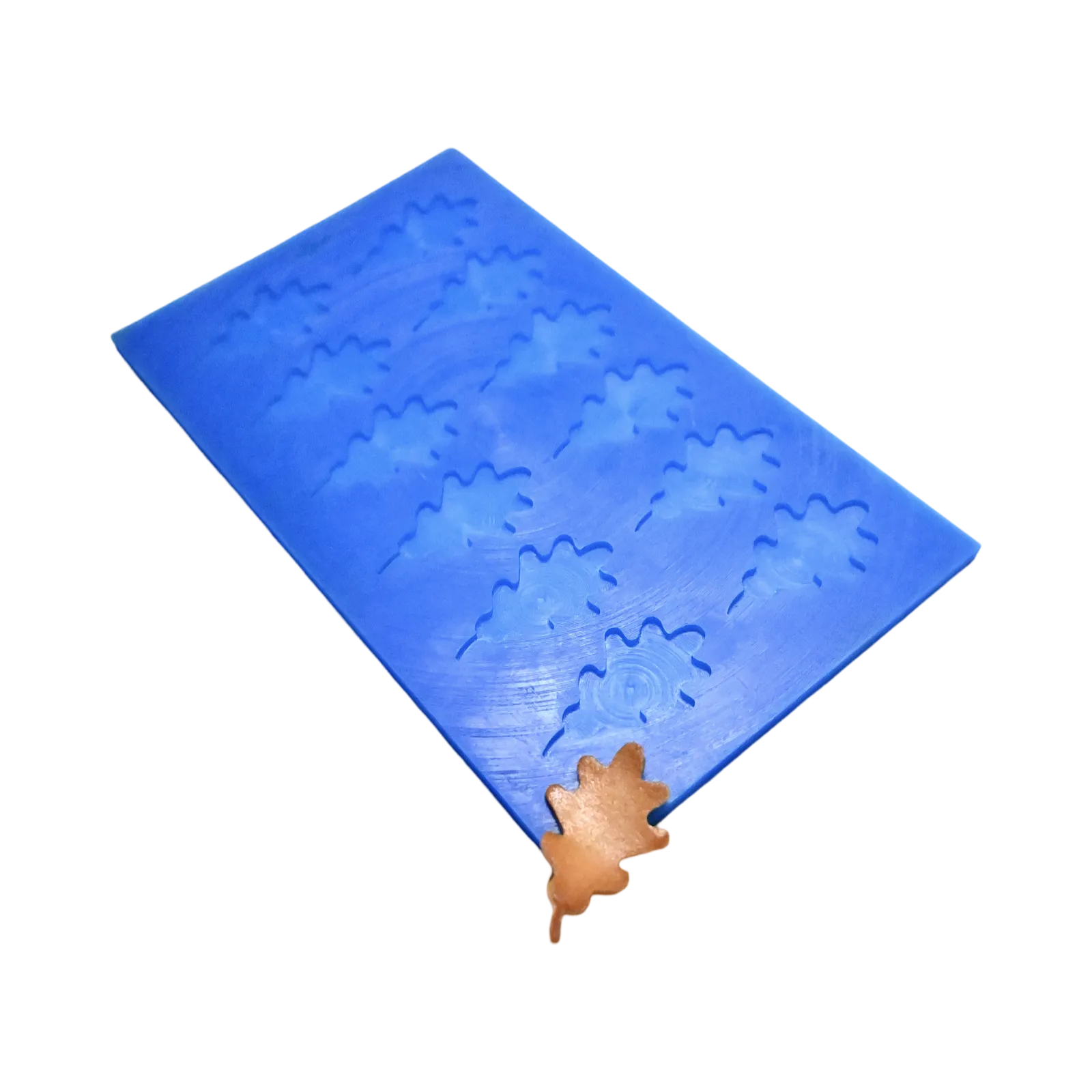 Blue silicone mat with oak leaf shaped molds and a brown leaf tuile garnish.