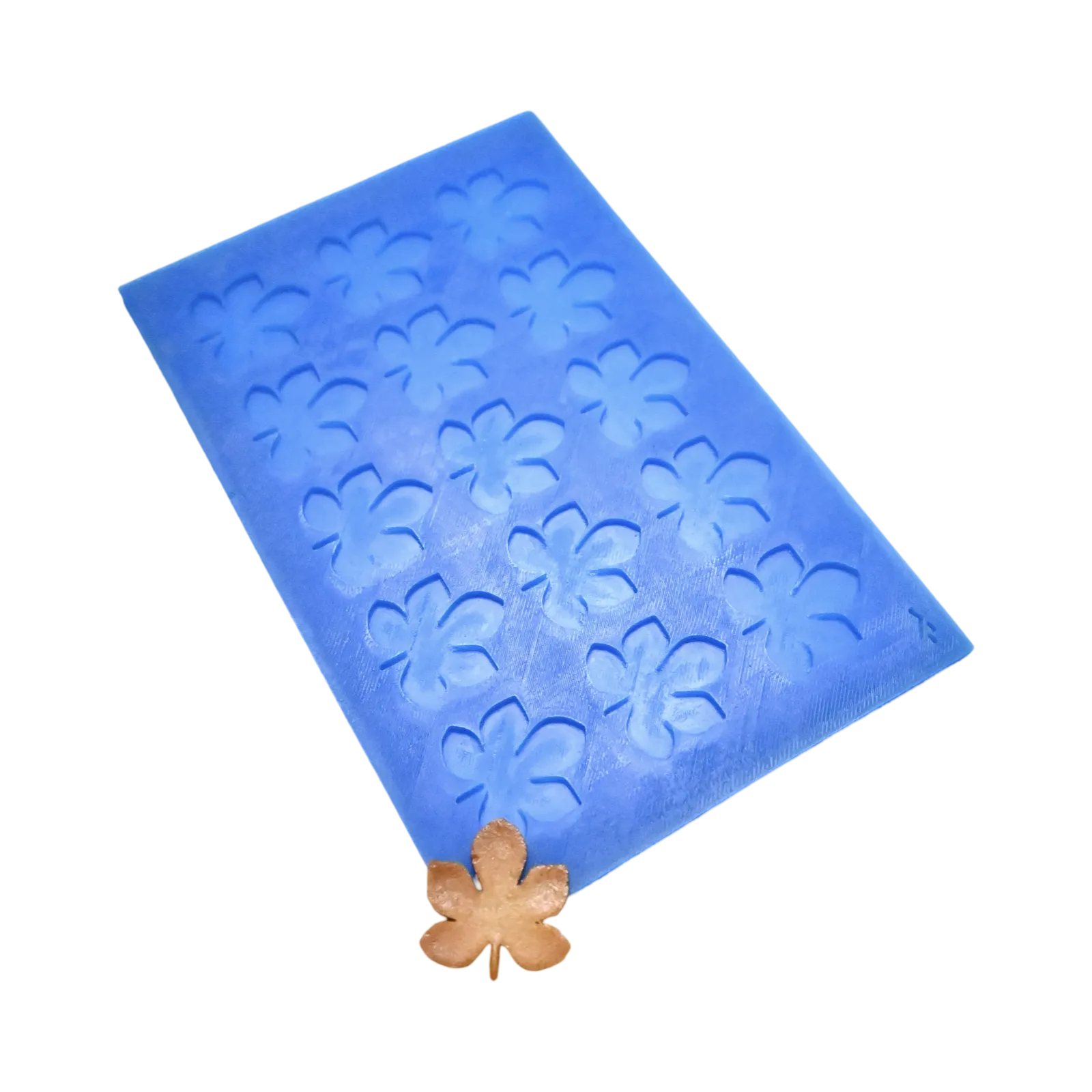 Blue silicone mat with horse chestnut leaf-shaped tuile molds and a golden leaf garnish.