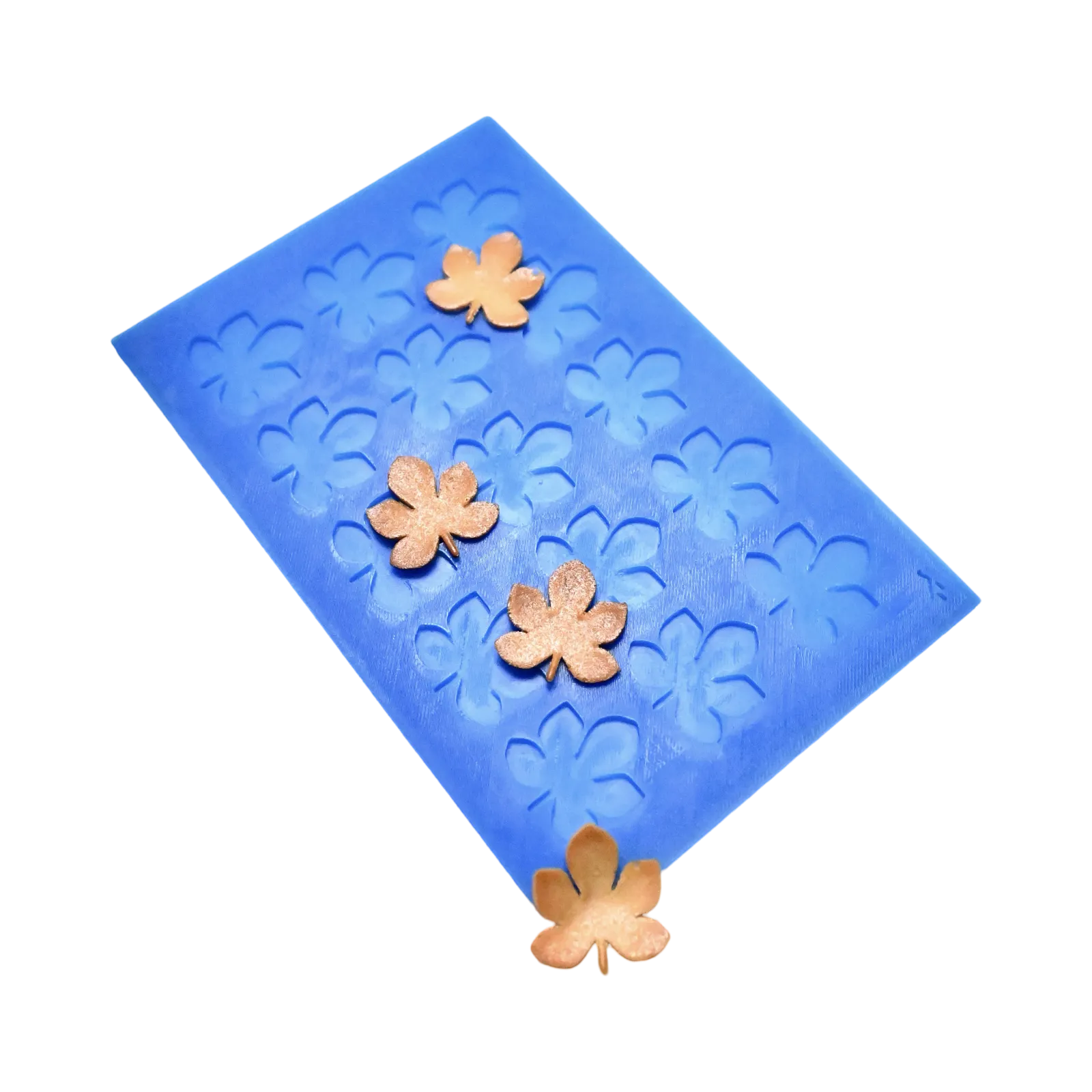 Blue silicone mat with horse chestnut leaf shaped molds and golden tuiles.