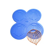 Blue silicone mat with four hazelnut tuile molds and a finished brown tuile.