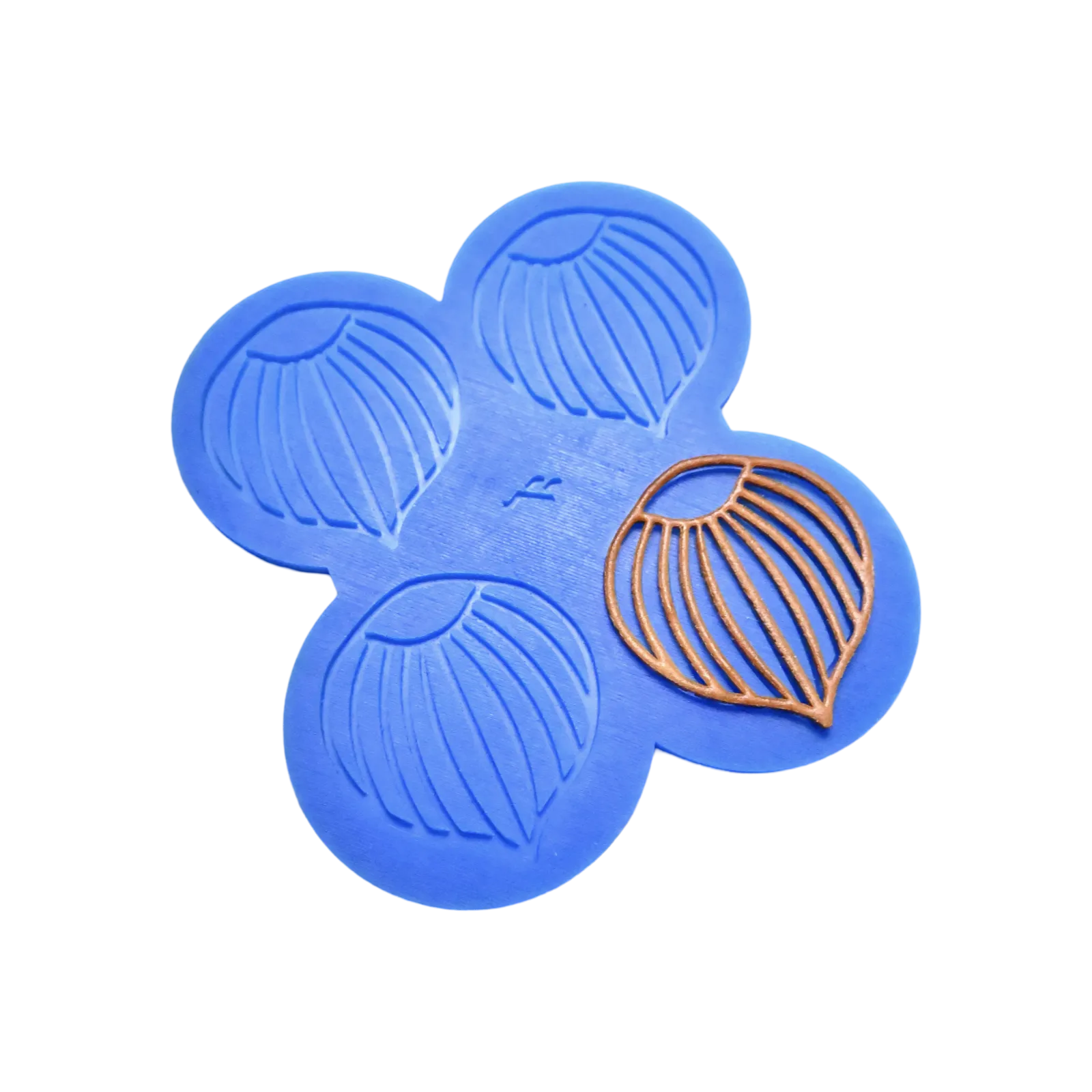 Blue silicone mat with four hazelnut-shaped tuile molds and one golden tuile piece.