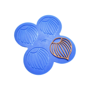 Blue silicone mat with four hazelnut-shaped tuile molds and one golden tuile piece.