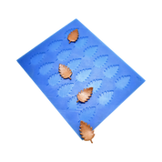 Blue silicone birch leaf tuile mold with brown leaf-shaped pastry decorations.