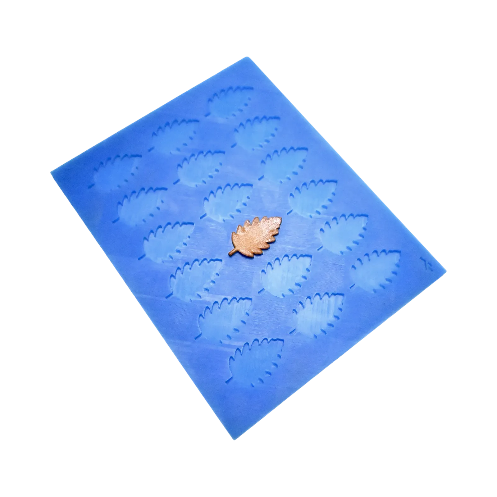Blue silicone mat with birch leaf shaped molds and a golden tuile leaf.