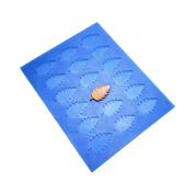 Blue silicone mat with birch leaf shaped molds and a golden tuile leaf.