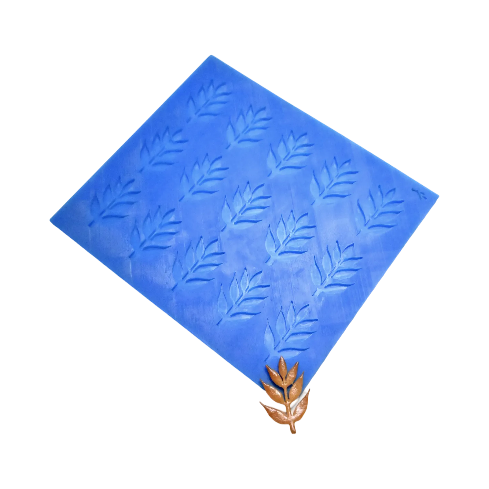 Blue silicone ash leaf tuile mold mat with a finished brown leaf-shaped pastry.