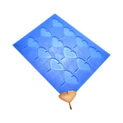 Blue silicone baking mat with ginkgo leaf shaped molds and a finished golden tuile.