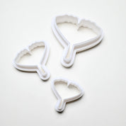 Three white plastic ginkgo leaf cookie cutters in small, medium, and large sizes.