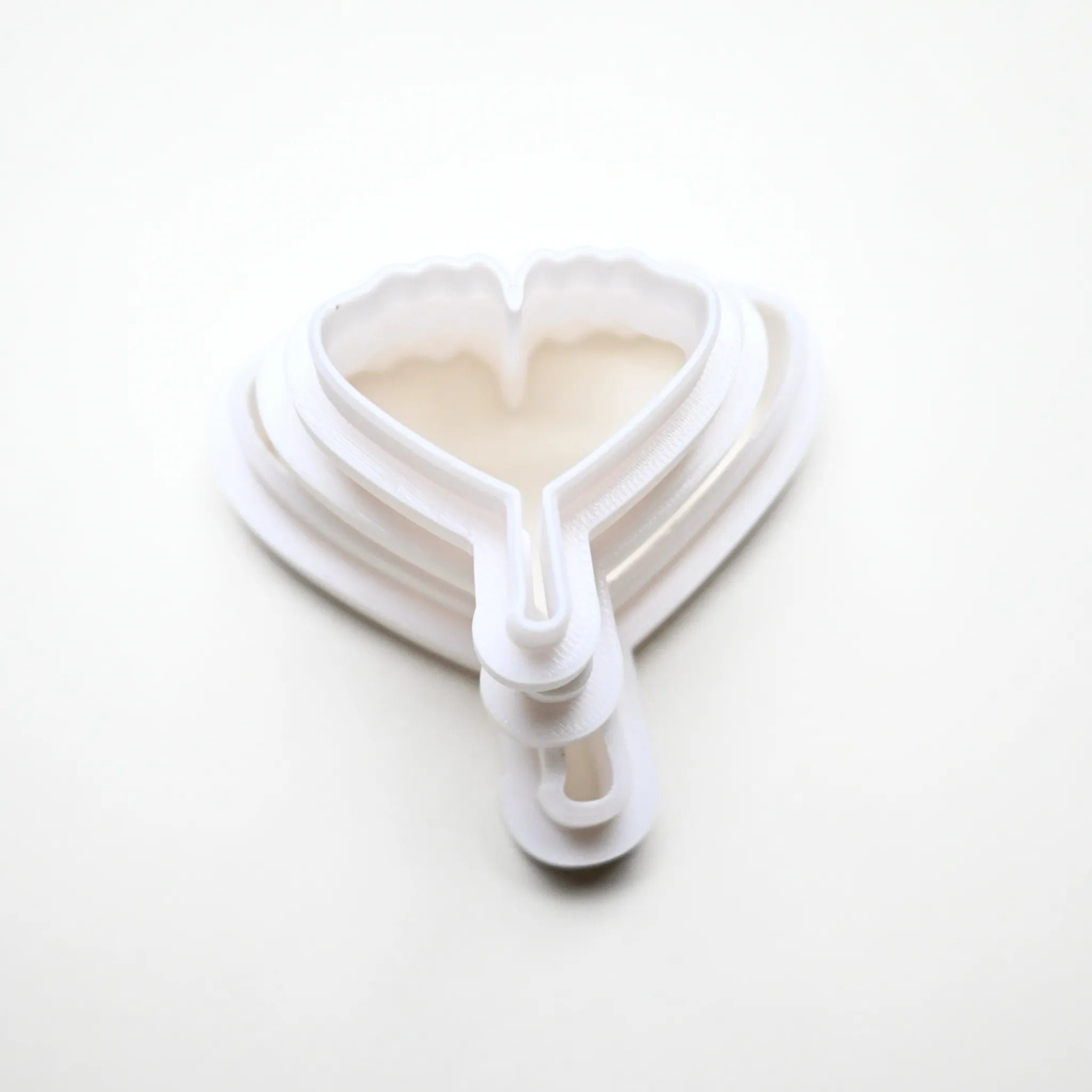 White plastic ginkgo leaf cookie cutters in nested sizes.