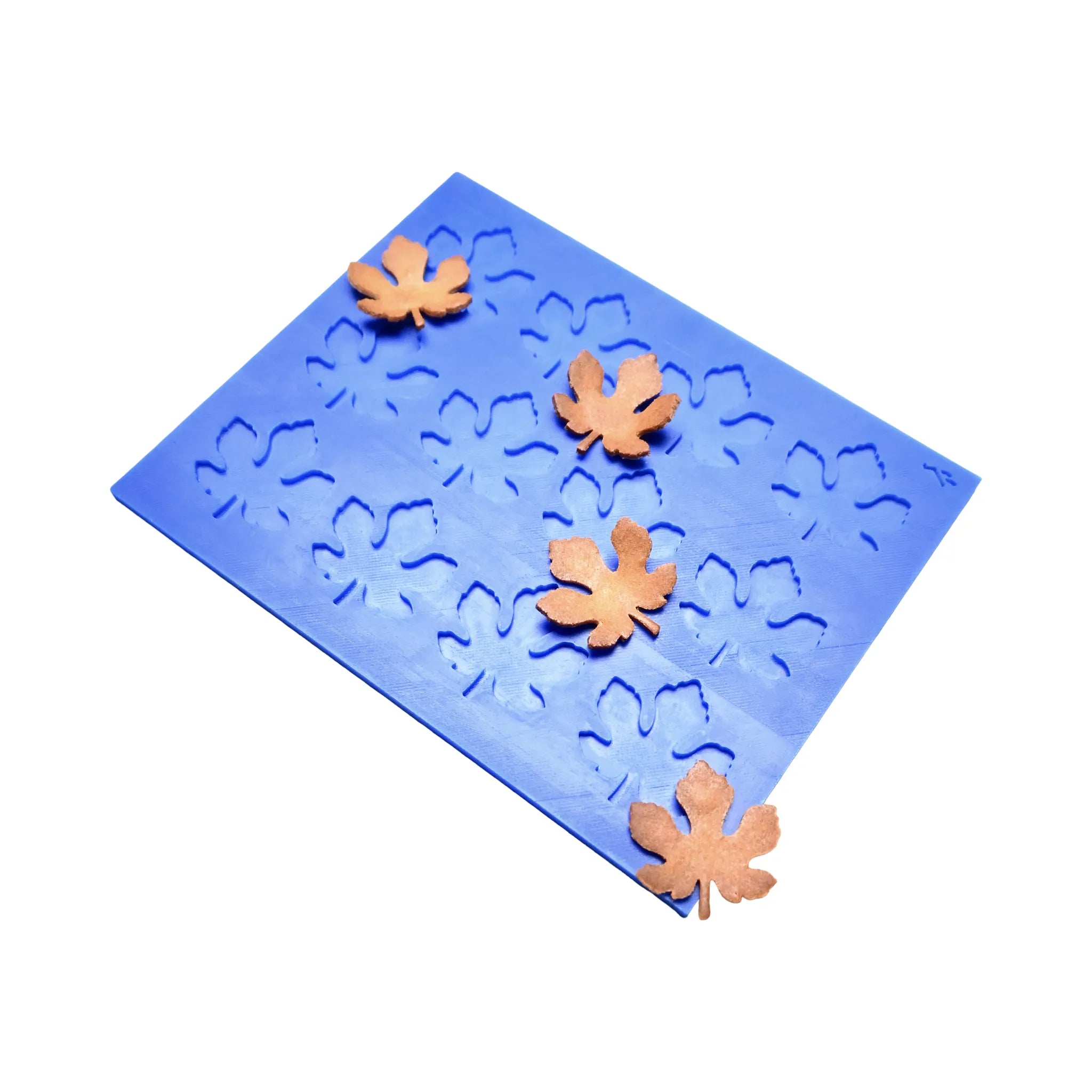 Blue silicone tuile mat with detailed fig leaf shaped molds and baked golden pastry leaves.