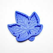 Blue silicone vine leaf mold with detailed, textured veins on a white background.