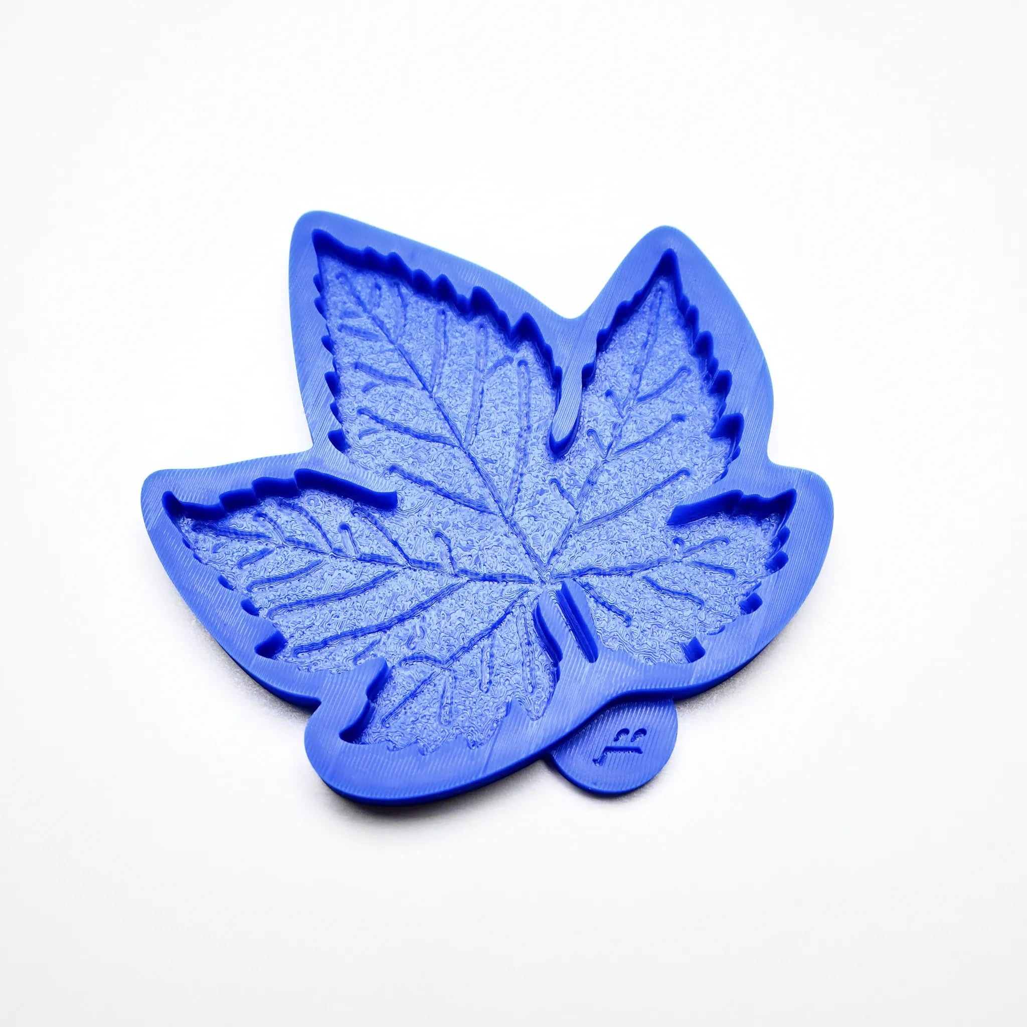 Blue silicone vine leaf mold with detailed, textured veins on a white background.