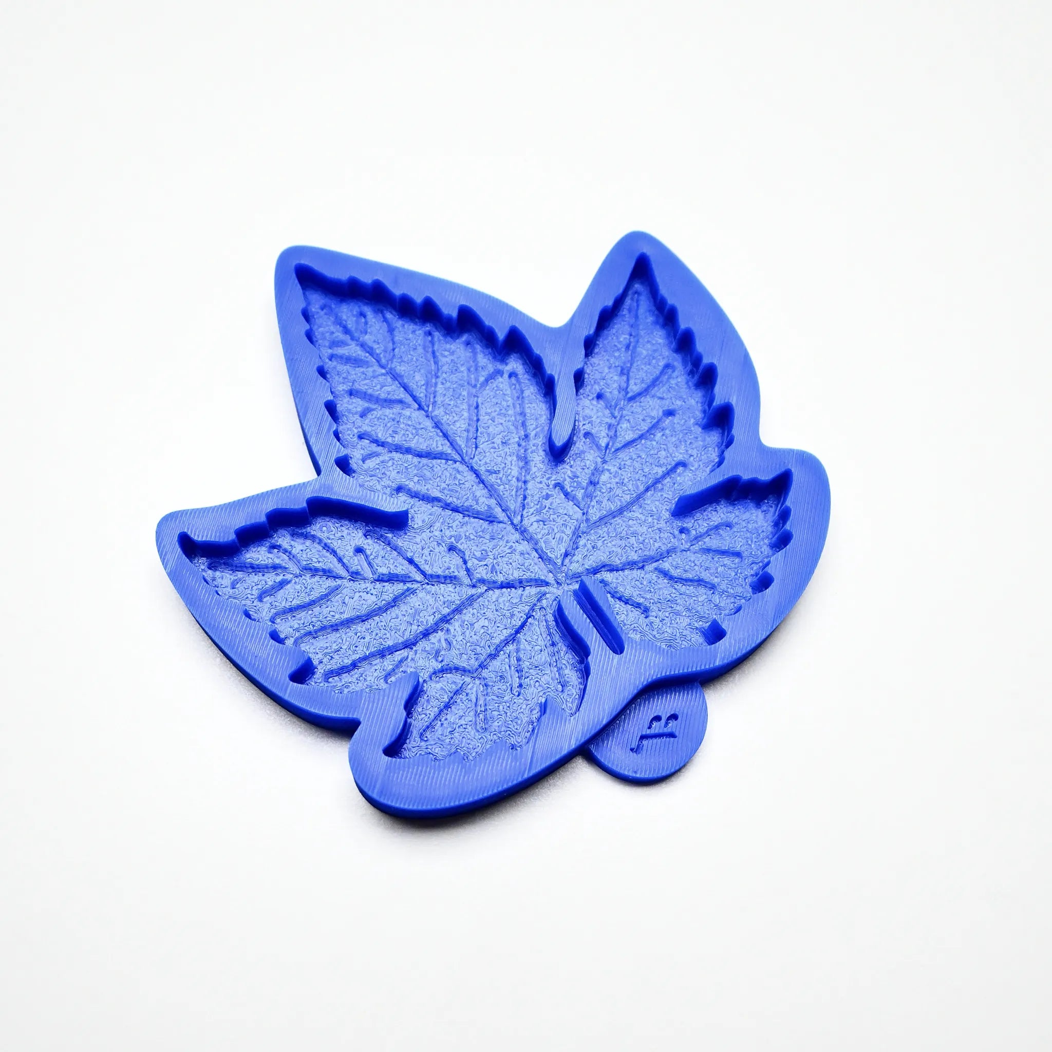 Blue silicone vine leaf mold with detailed, textured veins on a white background.