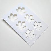 White plastic pastry stencil featuring six detailed fig leaf cutouts.