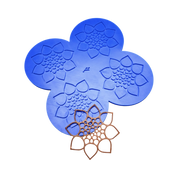Blue silicone CALYX tuile mat with four flower-shaped molds and a finished brown pastry tuile.