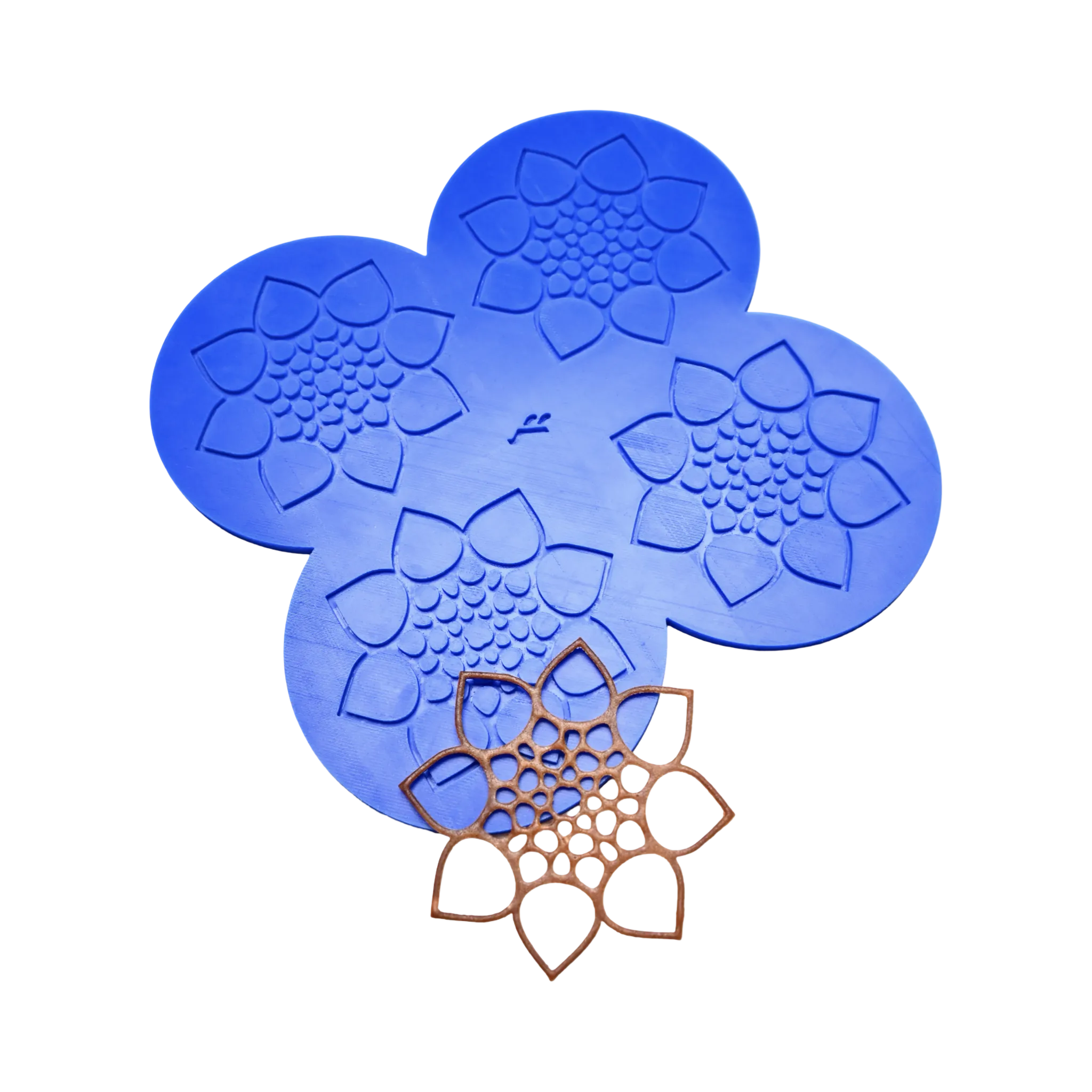 Blue silicone CALYX tuile mat with four flower-shaped molds and a finished brown pastry tuile.