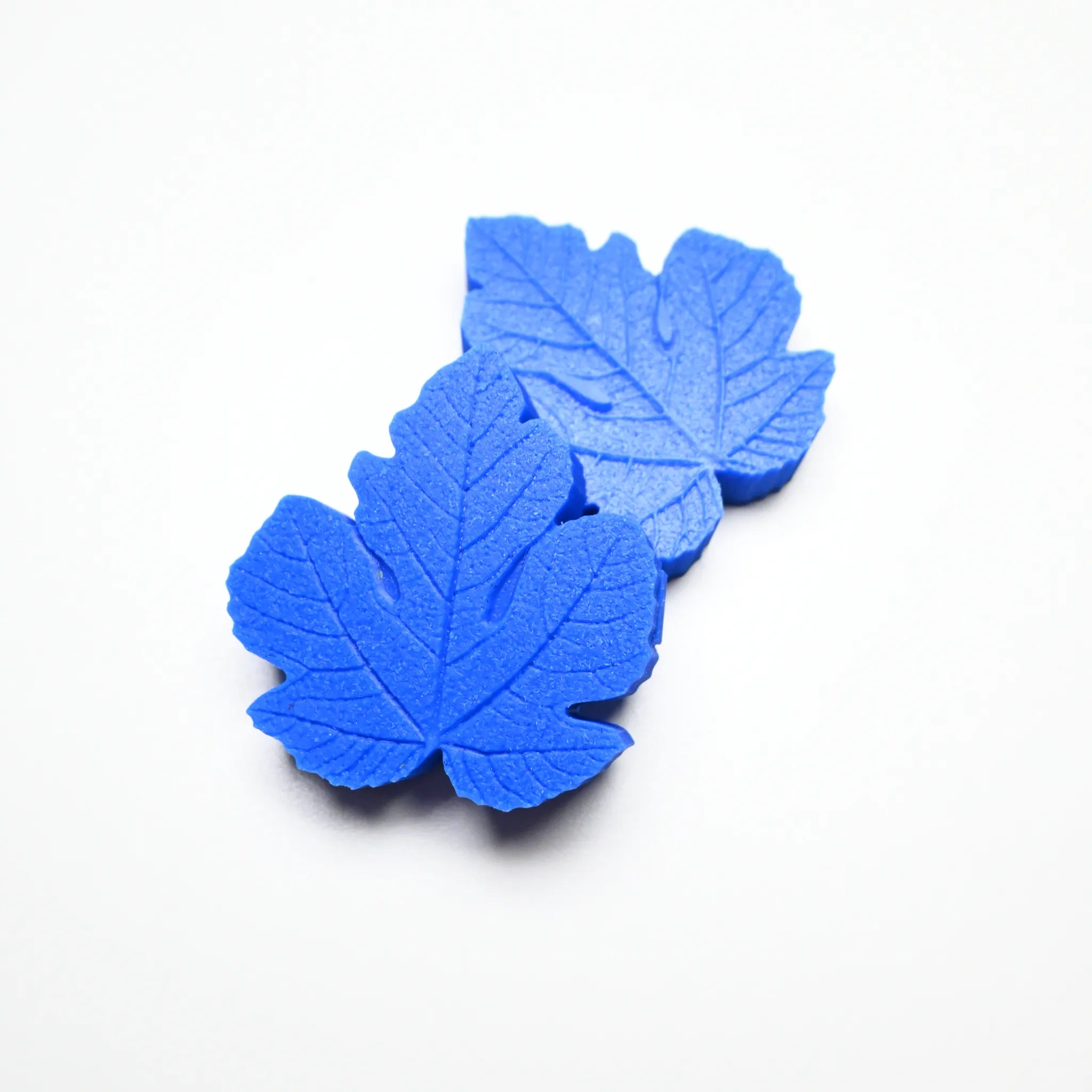 Blue silicone fig leaf veiners with detailed botanical textures on a white background.