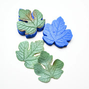 Blue silicone fig leaf veiner mold shown with realistic green fondant leaves.
