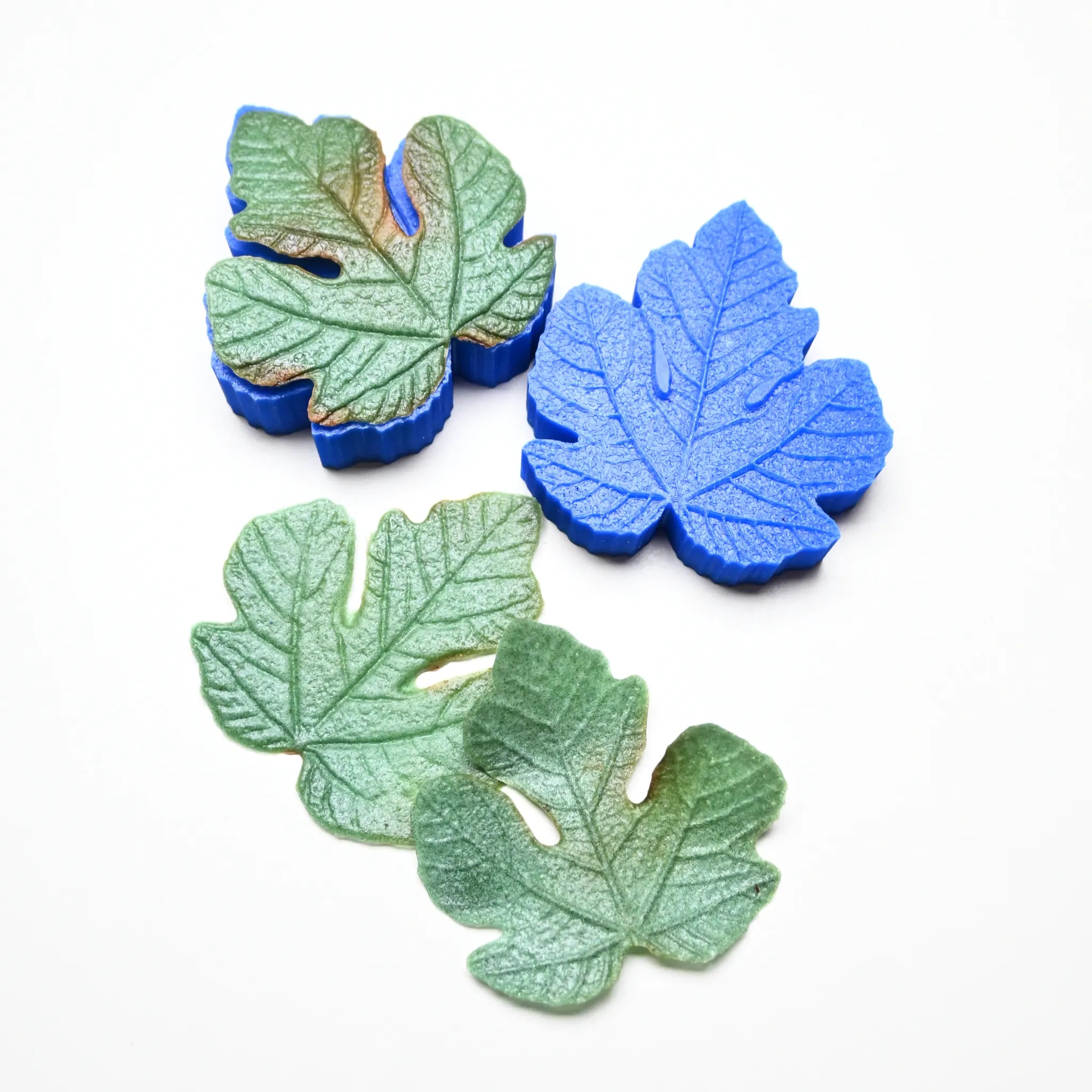Blue silicone fig leaf veiner mold shown with realistic green fondant leaves.